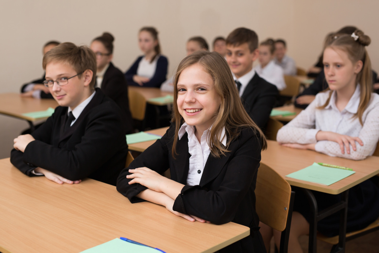 happy schoolchildren sit desk classroom